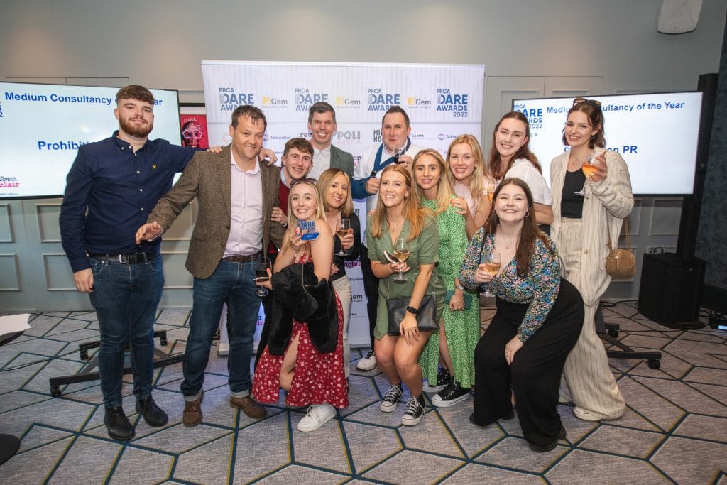 Group of people stood together holding an award