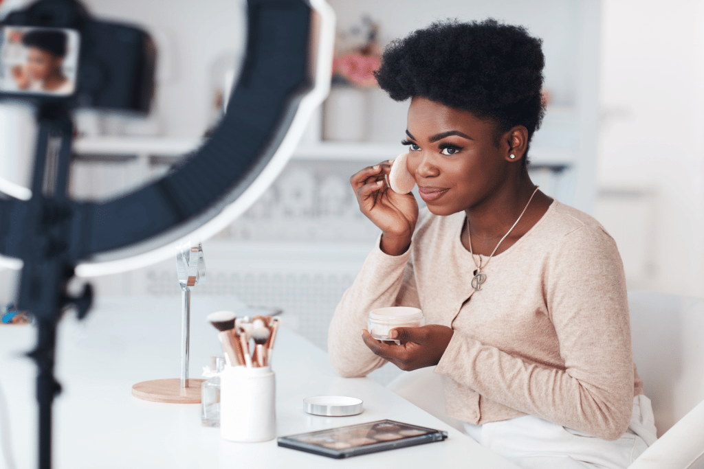 Influencer putting on makeup in front of a camera