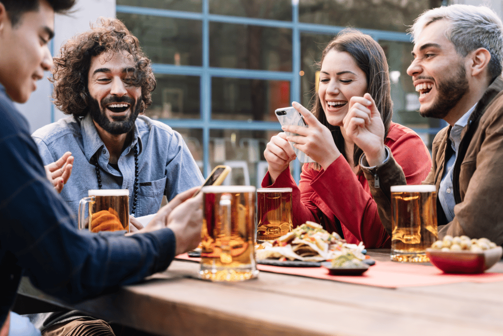 A group of people sat drinking and eating together at a table