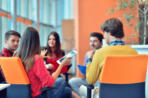 A group of people sat at a table speaking to each other