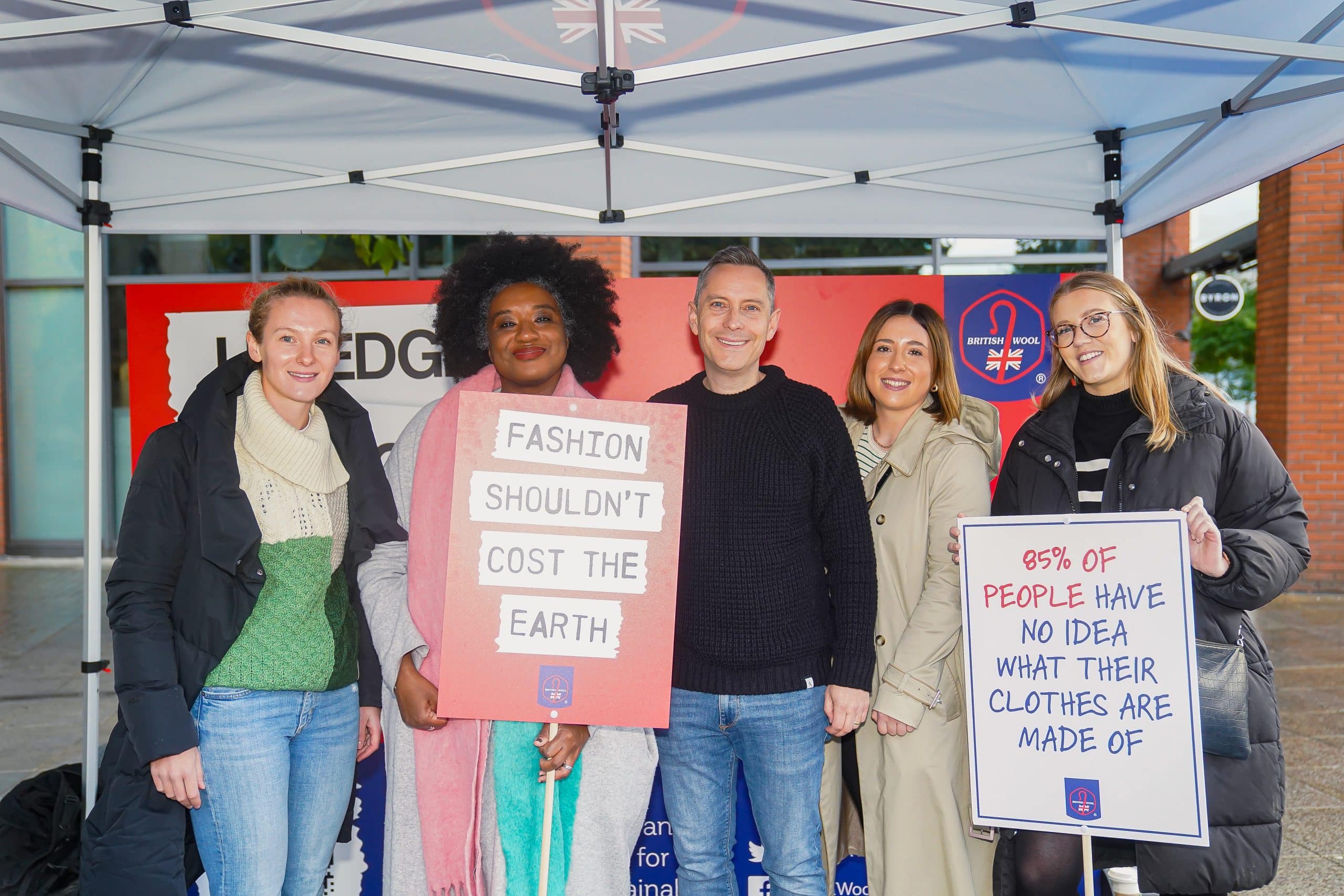 A group of people holding up signs at a stall