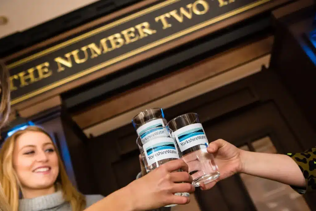 Glasses of Yorkshire Water raised at the bar of the Number Two Tavern