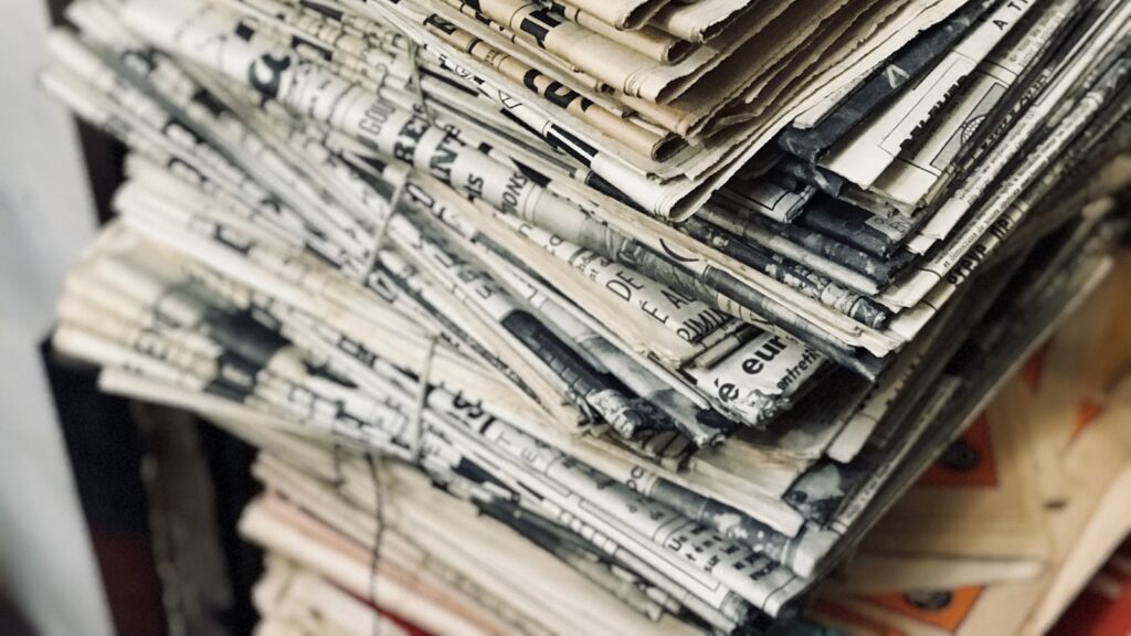 A bundle of newspapers on a table representing press coverage from a food product launch