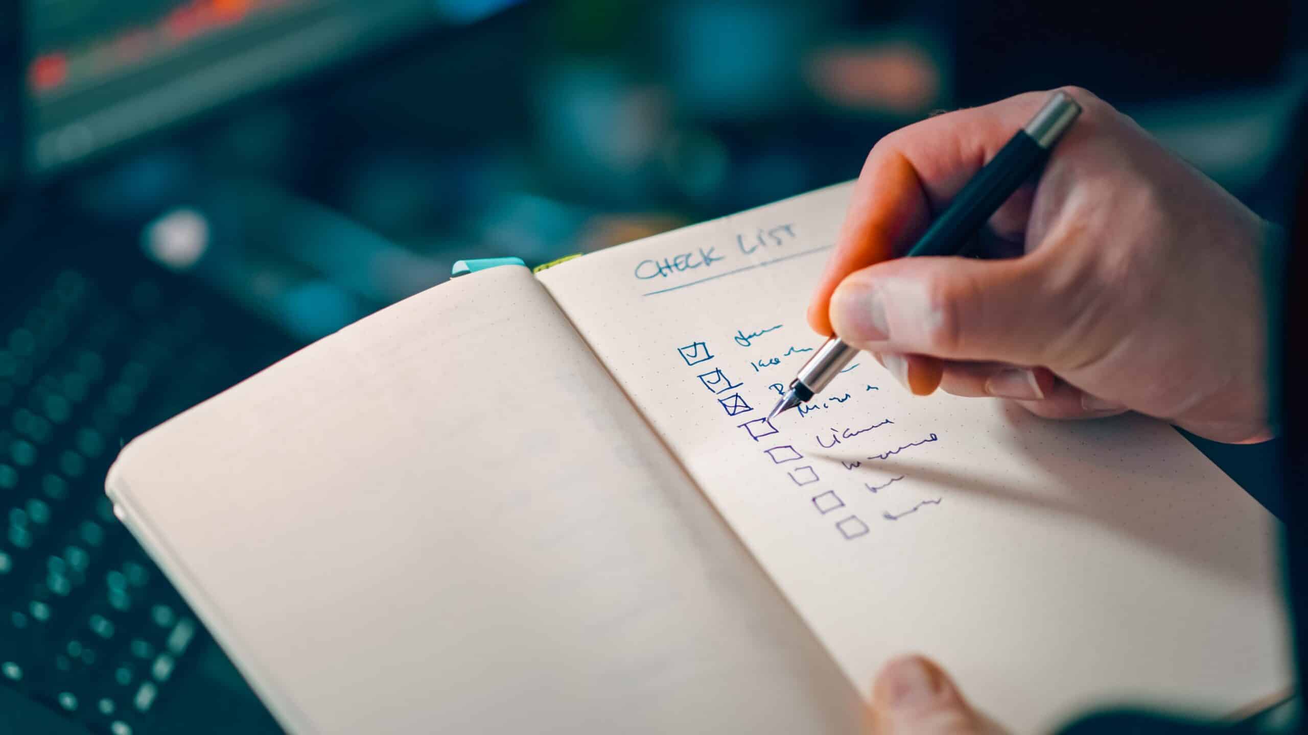 Hand writing a product launch checklist in a notebook, representing the four-phase PR checklist structure